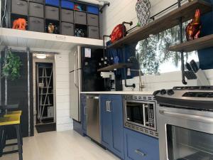 a kitchen with blue cabinets and a stove at Modern, pet friendly tiny house, No extra fees! in Clermont