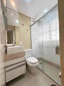 een badkamer met een toilet en een glazen douche bij Sol & Nascente in Guarujá
