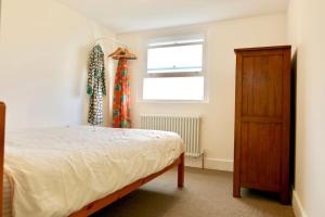 1 dormitorio con 1 cama, vestidor y ventana en North East London loft apartment. Stoke Newington., en Londres