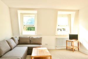 a living room with a couch and two windows at North East London loft apartment. Stoke Newington. in London