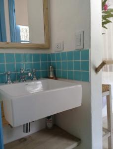 La salle de bains est pourvue d'un lavabo blanc et d'un miroir. dans l'établissement Habitación payesa en el bosque, La Barra, à Barra de Maldonado
