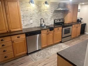 uma cozinha com armários de madeira e electrodomésticos de aço inoxidável em Streamview Retreat near I-77/40 em Statesville