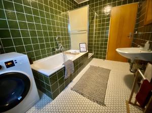 a green tiled bathroom with a sink and a toilet at KU-02RI Apartment in Kulmbach OG in Kulmbach