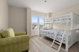 a bedroom with a bunk bed and a chair at Oceanfront Villa 1 - Boardwalk Oceanfront in Ocean City