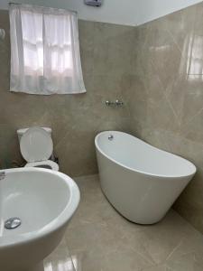Savaneta的住宿－La Villas at Pos Chiquito Caribbean Paradise in Aruba，浴室配有白色浴缸和卫生间。