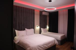 1 dormitorio con 2 camas y luz roja en Sky View Hotel & Restaurant, en Kukës