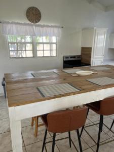 una mesa de cocina con sillas y un reloj en la pared en La Villas at Pos Chiquito Caribbean Paradise in Aruba en Savaneta