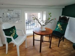 a room with two chairs and a table with a vase on it at Z widokiem- Old Town in Kraków
