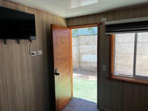 eine offene Tür zu einem Zimmer mit einem TV und einer Tür in der Unterkunft Alojamiento Rústico Belloto 4 in Quilpué