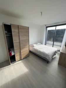 a bedroom with a bed and a large window at Chambre double balcon vue mer in Brest
