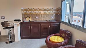 a kitchen with a sink and a counter with chairs at Joli jardin en ville in Yaoundé