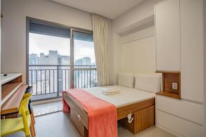 a bedroom with a bed and a large window at Piscina no Rooftop! Studio a 3min do Metrô República in São Paulo +25 photos