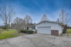 a house with a white garage in a driveway at Spacious Delaware Home with Private Hot Tub! in Delaware