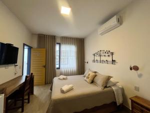 a bedroom with a bed with two towels on it at Pousada Pouso de Laura in Tiradentes