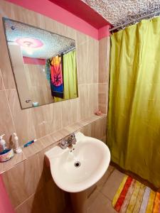 a bathroom with a sink and a green shower curtain at Cindy's Garden Stay in Ocho Rios