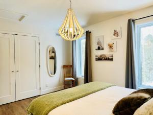 1 dormitorio con cama y lámpara de araña en Woodpecker Spa and peace, en Orford