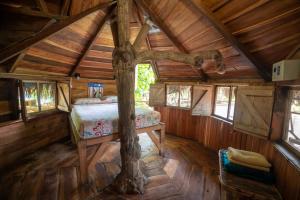 a bedroom in a log cabin with a bed in it at The Sea Garden House in Olón