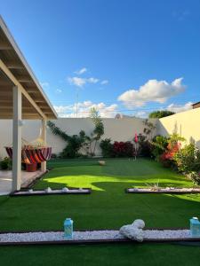 a garden with green grass and a building at La Villas at Pos Chiquito Caribbean Paradise in Aruba in Savaneta