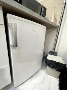a small kitchen with a white refrigerator and a toilet at appartement entier sur Reims - 4 Voyageurs in Reims