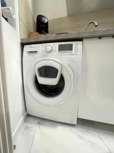 uma máquina de lavar roupa numa cozinha com um lavatório em appartement entier sur Reims - 4 Voyageurs em Reims