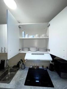 a kitchen with white cabinets and a sink and a counter at appartement entier sur Reims - 4 Voyageurs in Reims
