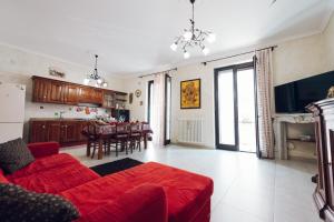 een woonkamer met een rode bank en een keuken bij LE QUATTRO STAGIONI in Brindisi