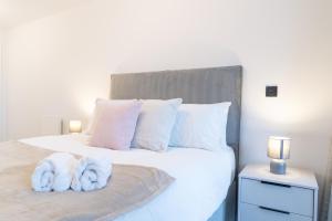 a bedroom with a bed with white towels on it at Apex Lofts Suite - Modern 2 bed with rooftop terrace in Birmingham