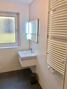 a white bathroom with a sink and a window at Sanierte 2 Zimmer Wohnung am CentrO in Oberhausen in Oberhausen