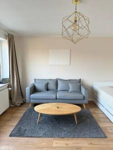 Sala de estar con sofá azul y mesa de centro en Sanierte 2 Zimmer Wohnung am CentrO in Oberhausen, en Oberhausen