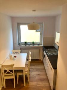 eine Küche mit einem Tisch, einem Tisch und einem Fenster in der Unterkunft Sanierte 2 Zimmer Wohnung am CentrO in Oberhausen in Oberhausen