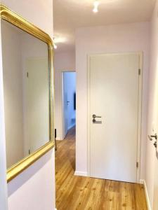 un couloir avec un miroir et une porte blanche dans l'établissement Sanierte 2 Zimmer Wohnung am CentrO in Oberhausen, à Oberhausen
