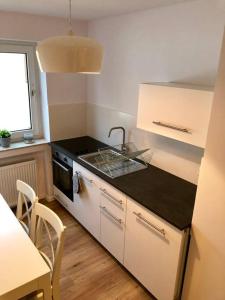 een kleine keuken met een wastafel en een fornuis bij Sanierte 2 Zimmer Wohnung am CentrO in Oberhausen in Oberhausen