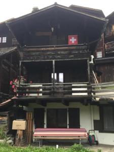 un edificio con un banco delante de él en Chalet familial, en Grimentz