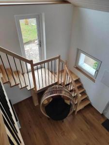 um quarto com uma escada em espiral e uma janela em Unterkunft la maisonette em Saignelégier