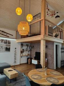 a living room with a table and a loft at Unterkunft la maisonette in Saignelégier