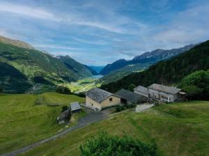 an aerial view of a farm in a valley at Monte Campell Dasura in Poschiavo