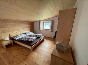 a bedroom with a bed in a wooden cabin at Monte Campell Dasura in Poschiavo