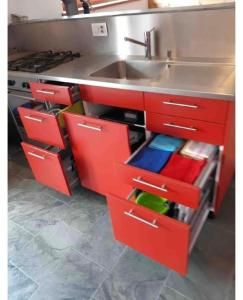 a kitchen with red cabinets and a sink at Monte Campell Dasura in Poschiavo