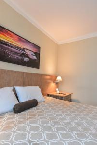 a bedroom with a large bed with a large painting on the wall at Premium room Berrini in Sao Paulo