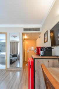 Premium room Berrini في ساو باولو: غرفة بها ثلاجة حمراء وغرفة معيشة