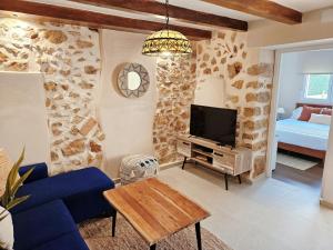 a living room with a blue couch and a tv at Casa Galia in Alcalalí