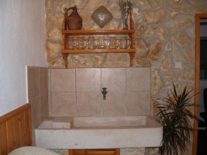 a bath tub in a bathroom with a stone wall at Apartments PHARIA in Jelsa +47 photos