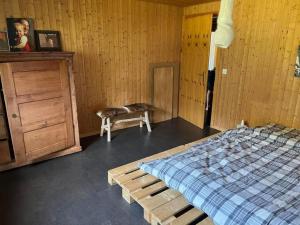 a bedroom with a bed and a wooden wall at Gemütliche 45 Zimmerwohnung in den Bündner Bergen bei Sedrun in Rueras