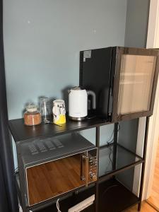 a microwave on top of a shelf with a toaster at Stue, soverom og bad in Åmot