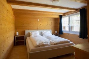 Bett in einem Zimmer mit einer Holzwand in der Unterkunft Ferienwohnung Wintersberg in Ebnat