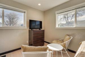 a living room with a tv and a table and two windows at Quiet and Convenient Reno Studio Less Than 2 Mi to Downtown! in Reno