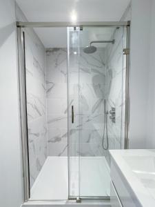 a shower with a glass door in a bathroom at Apex Lofts Suite - Modern 2 bed with rooftop terrace in Birmingham
