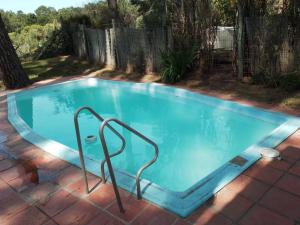 a swimming pool with a metal rail in a yard at Altamira 1 in Punta del Este