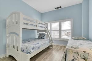 a bedroom with two bunk beds and a window at Oceanfront Villa 2(103) - Boardwalk oceanfront in Ocean City