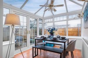 a dining room with a table and a ceiling fan at 3 Bedroom Delight, free parking in Milton Keynes